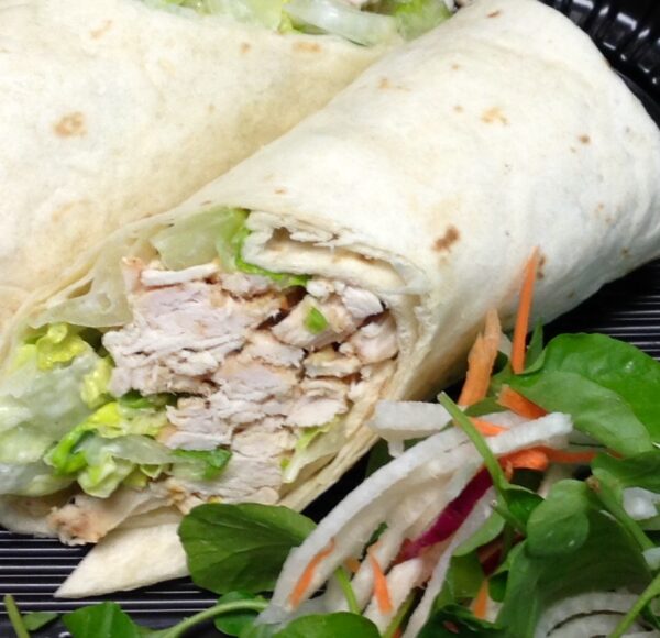 A close up of a wrap with meat and vegetables