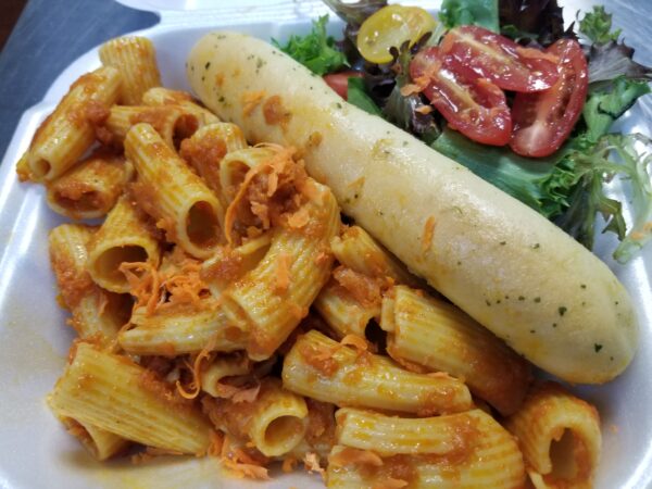 A plate of pasta and salad with meat sauce.
