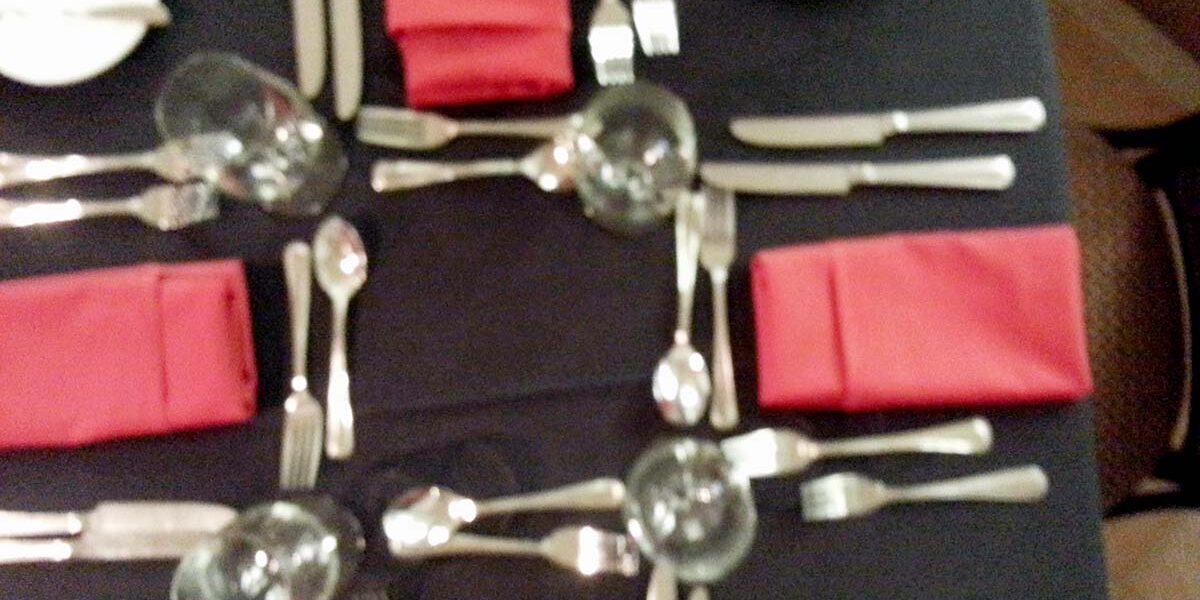 A table with silverware and napkins on it