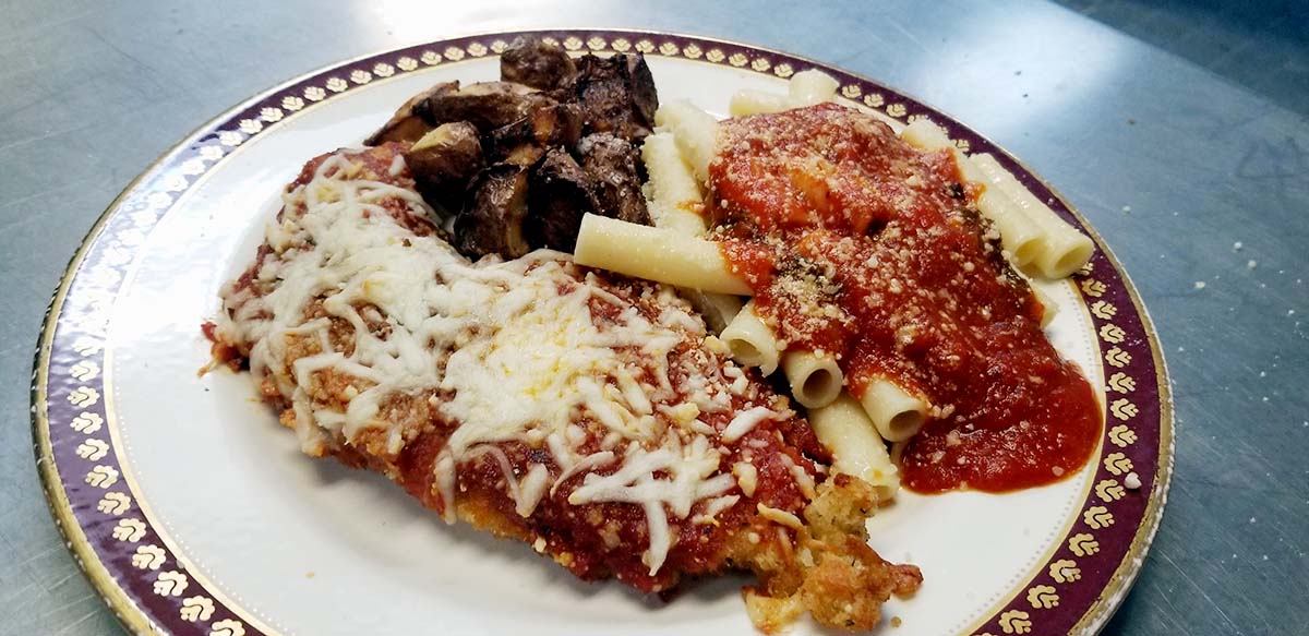 A plate of food with meat and pasta on it.