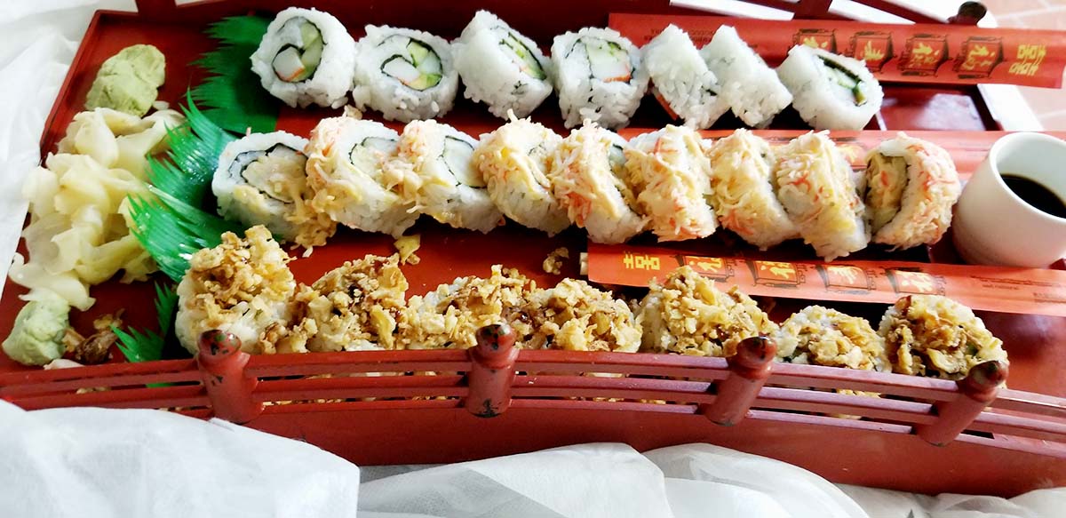 A tray of sushi rolls with various toppings.