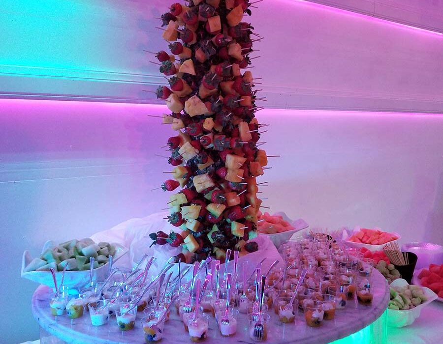 A display of food on a table with lights in the background.