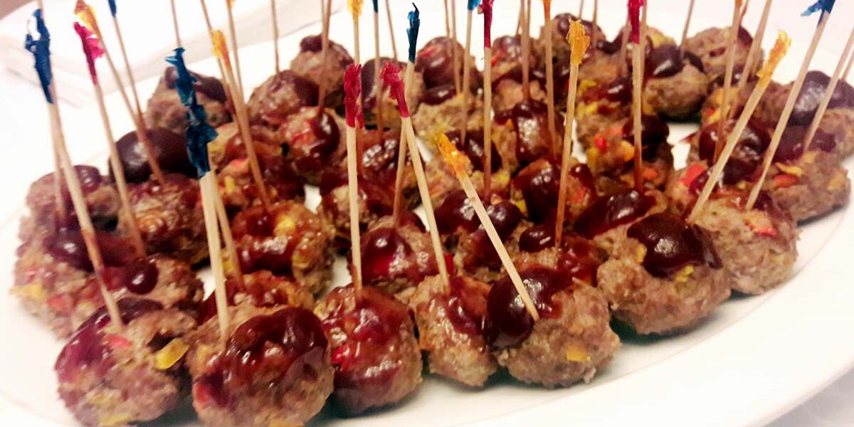 A plate of meatballs with toothpicks on top.