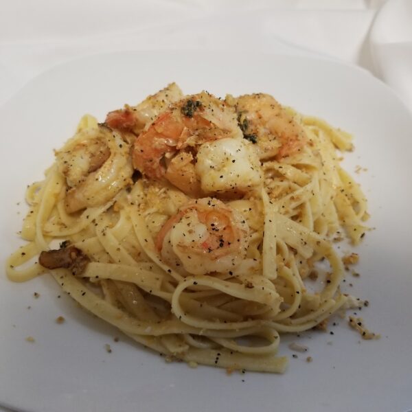 A plate of pasta with shrimp and cheese.