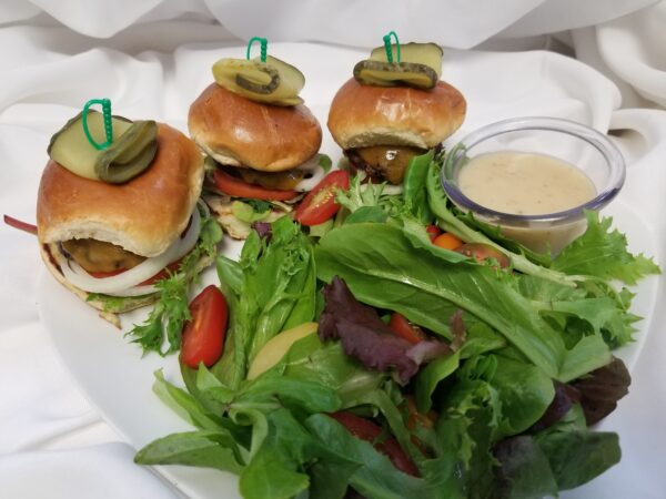 A plate of food with hamburgers and salad.