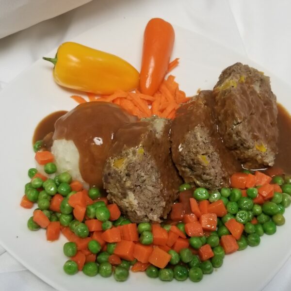 Meatloaf, mashed potatoes, and carrots and peas