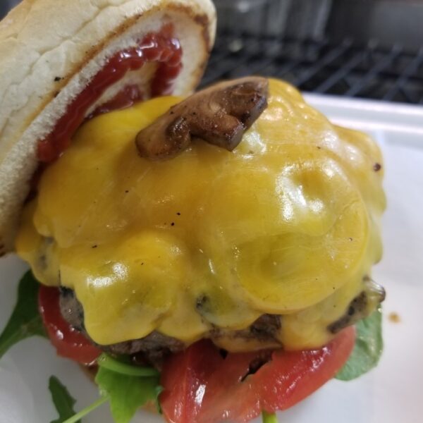 A cheeseburger with melted cheese on top of it.