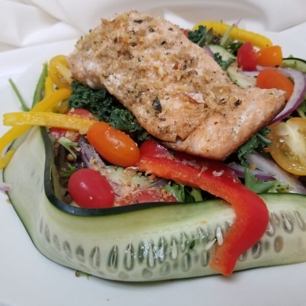 A plate of food with salmon and vegetables.